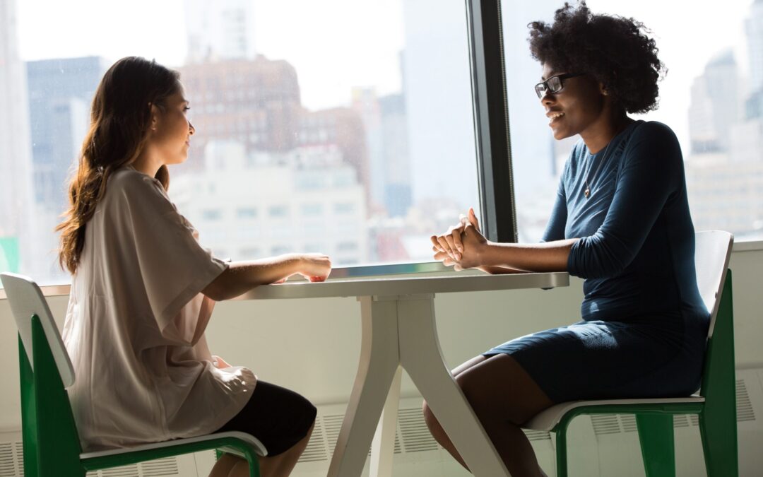 two people talking facing each other at a table