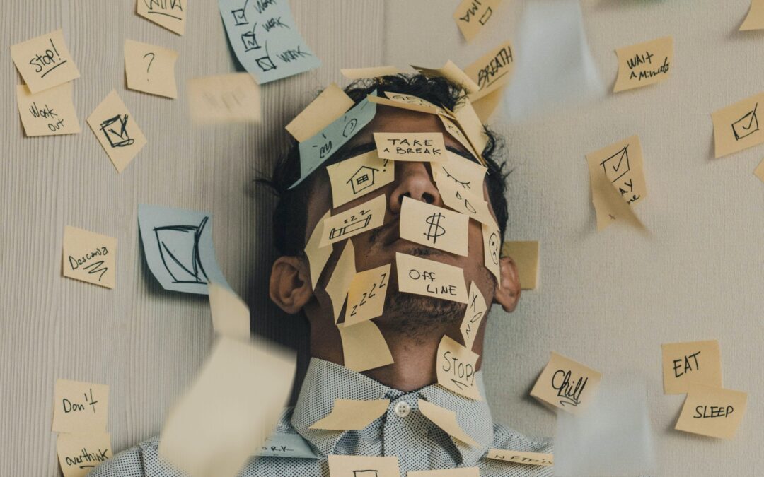 Young man covered in sticky notes, work overload