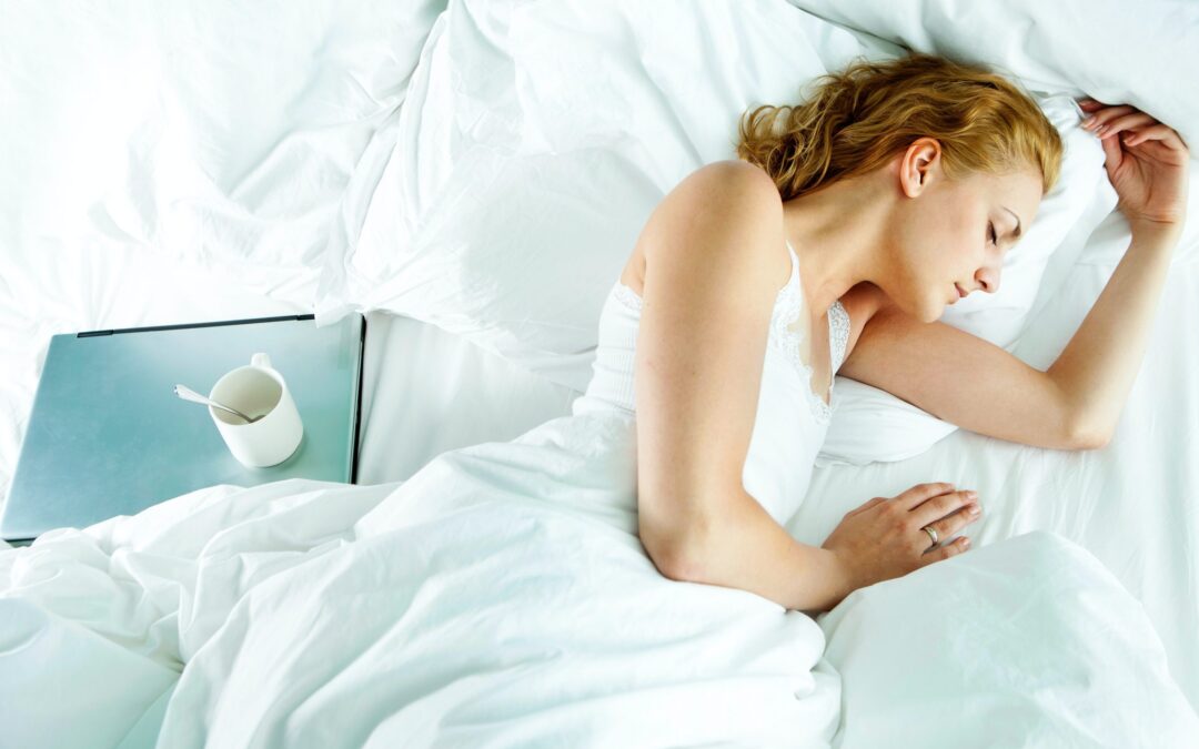 A woman is sound asleep with her laptop nearby