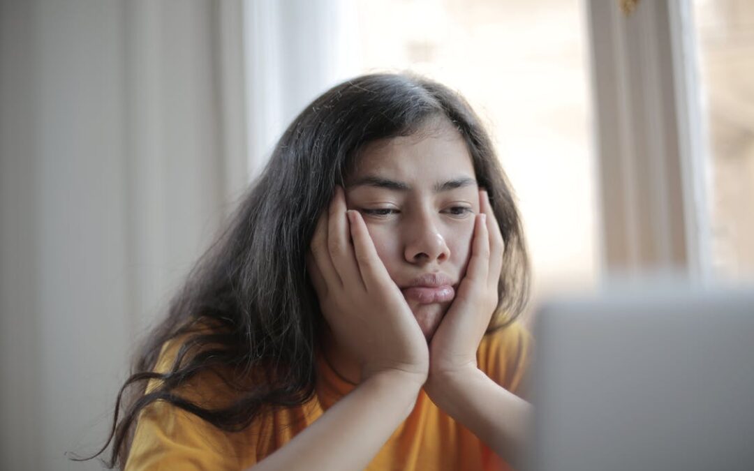 A young girl holding her face in her hands