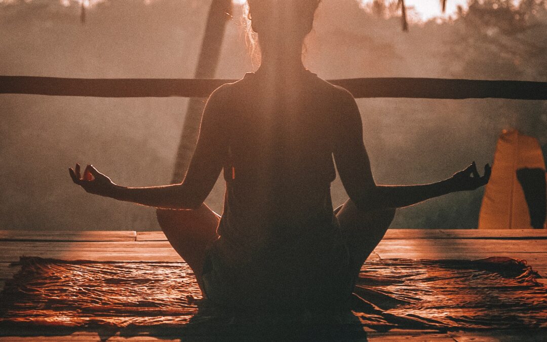 The view from the back of a woman meditating in lotus position