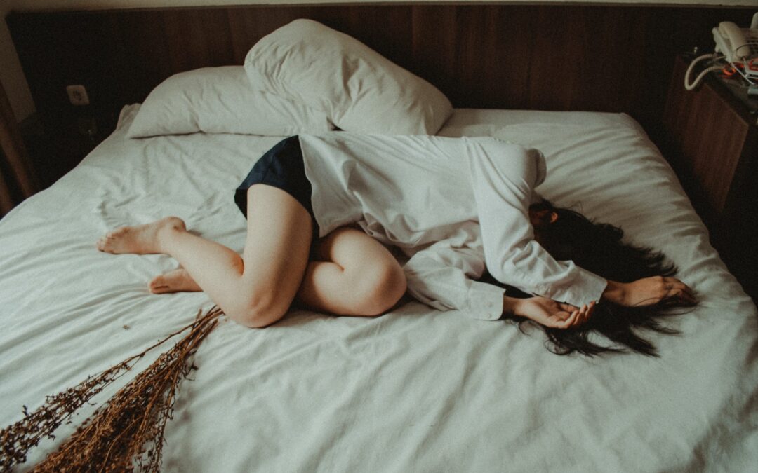 A girl lying down on a bed on her left side