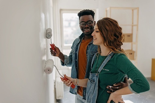 Young couple painting the walls during a house remodeling