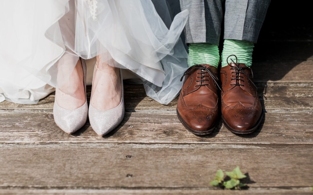 two peoples feet wearing nice attire that would be worn during a wedding