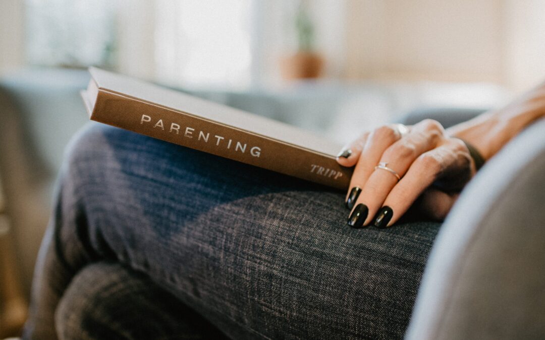 an image of a book on a womans lap entitled - "Parenting" by Tripp