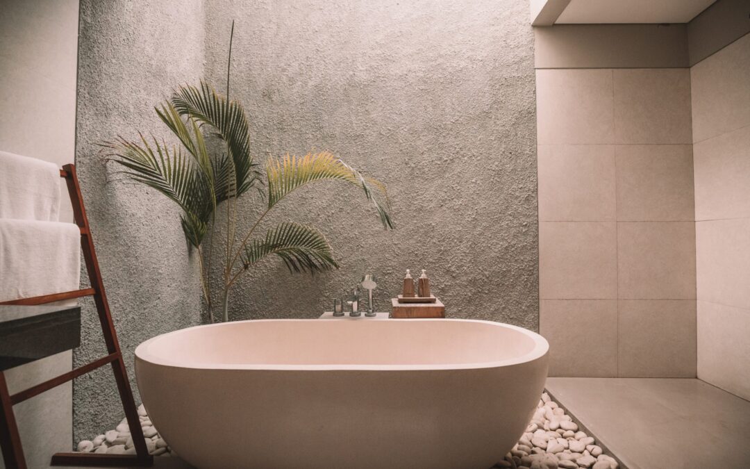 a very nice bathroom with a tub situated on rocks and tile. So nice.