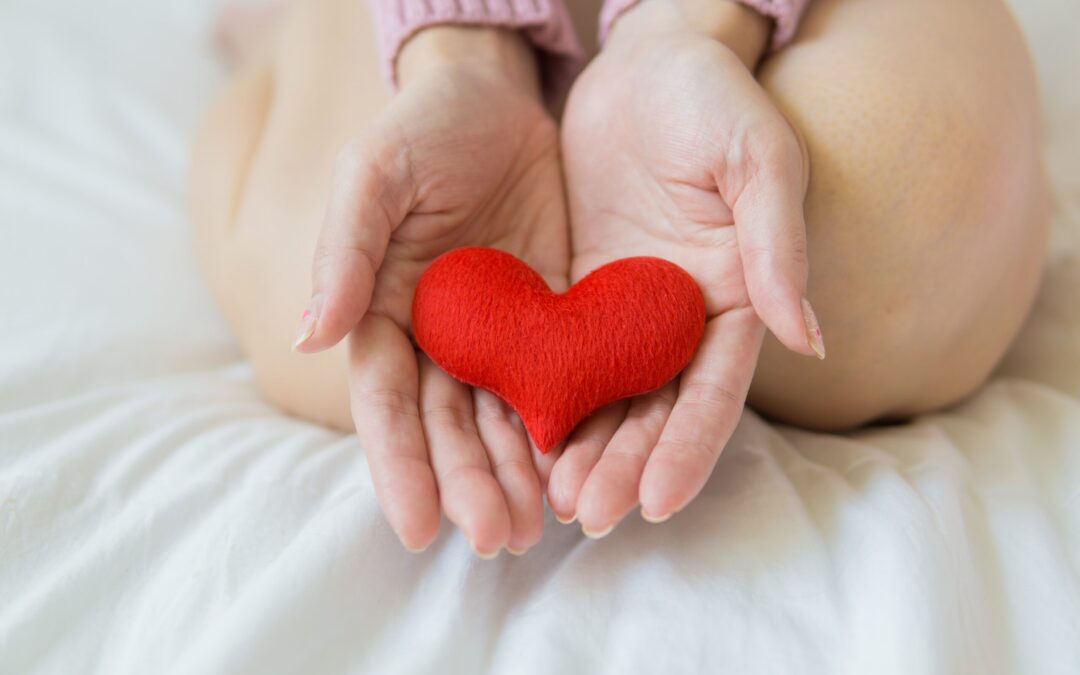 red heart being held between two hands