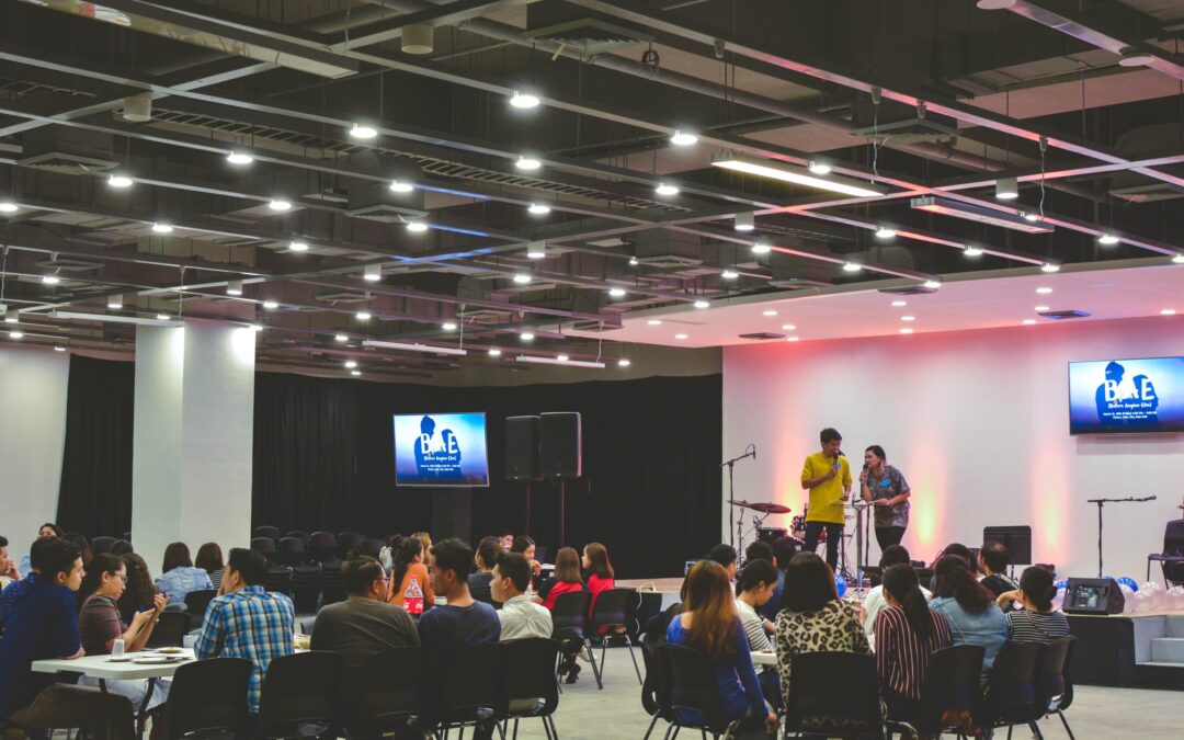 people on a stage are talking to a group of people.