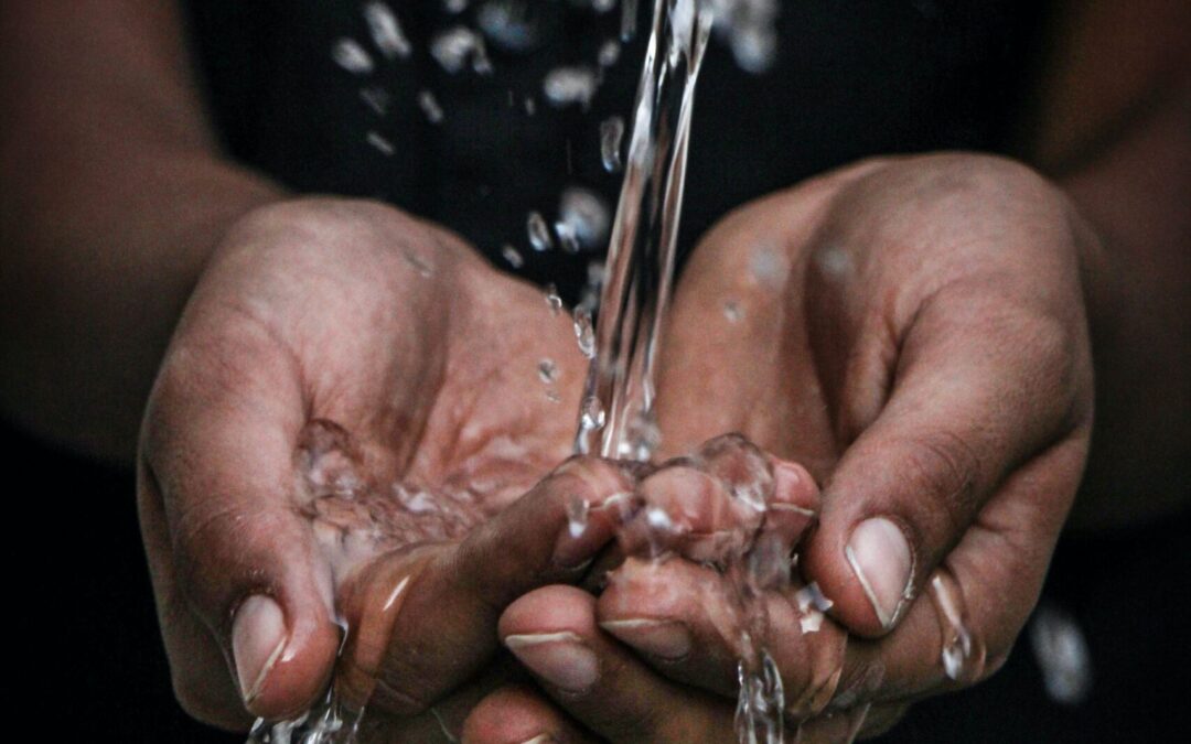 a stream of water is splashing into someones open hands