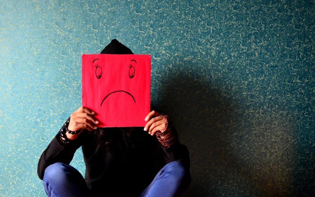 unhappy face on a board in front of a person sitting down