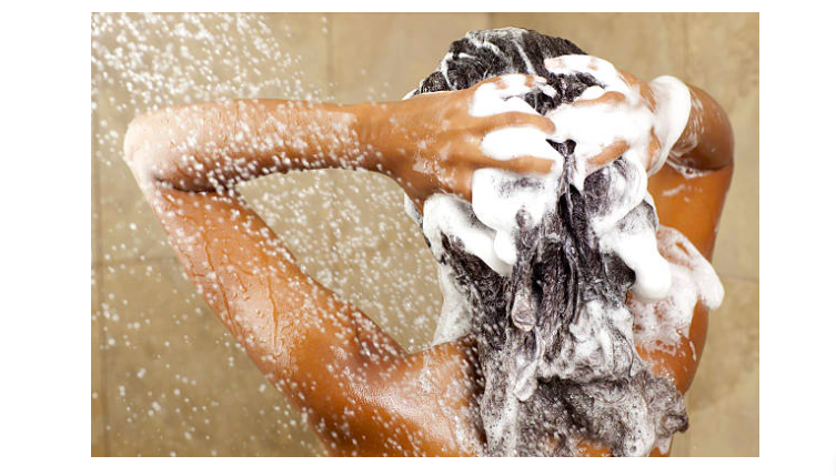 a woman in a shower with shampoo on her hair