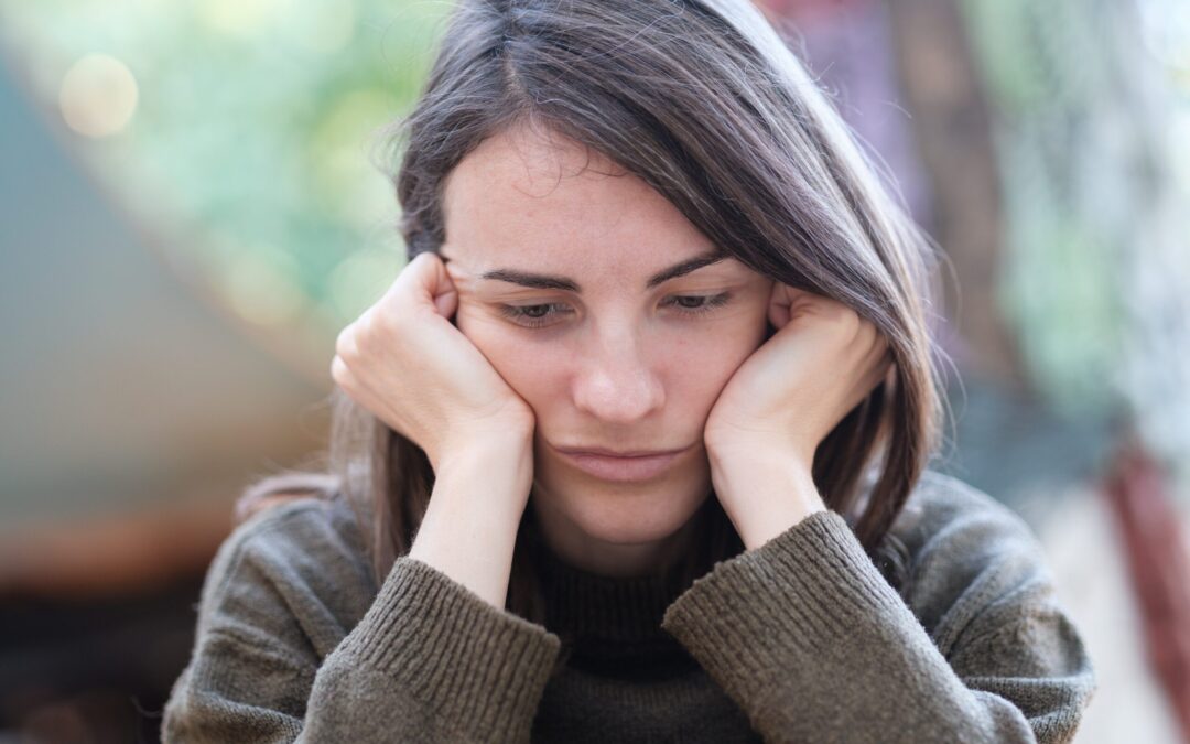 An unhappy woman thinking about accessing digital mental health resources 