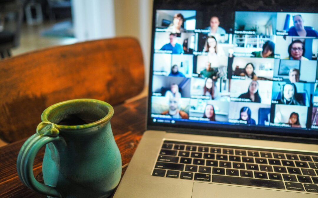 A picture of laptop with a mug - the laptop is hosting a zoom session.