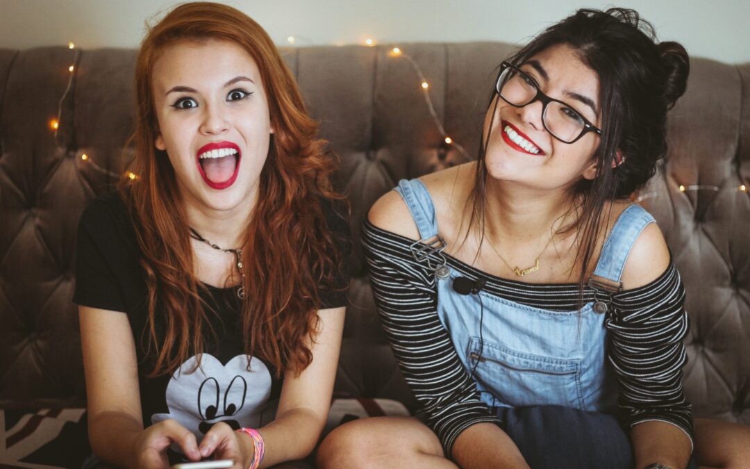 Teenage girls on couch with animated expressions